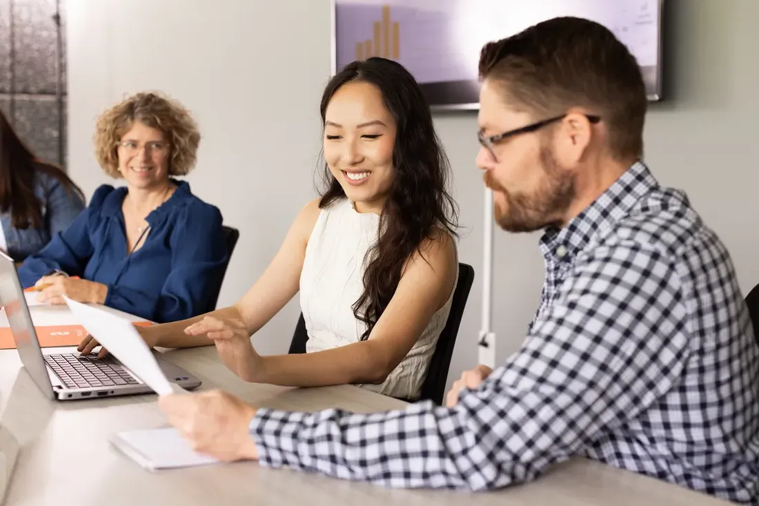 Three people at a table looking at a piece of paper.